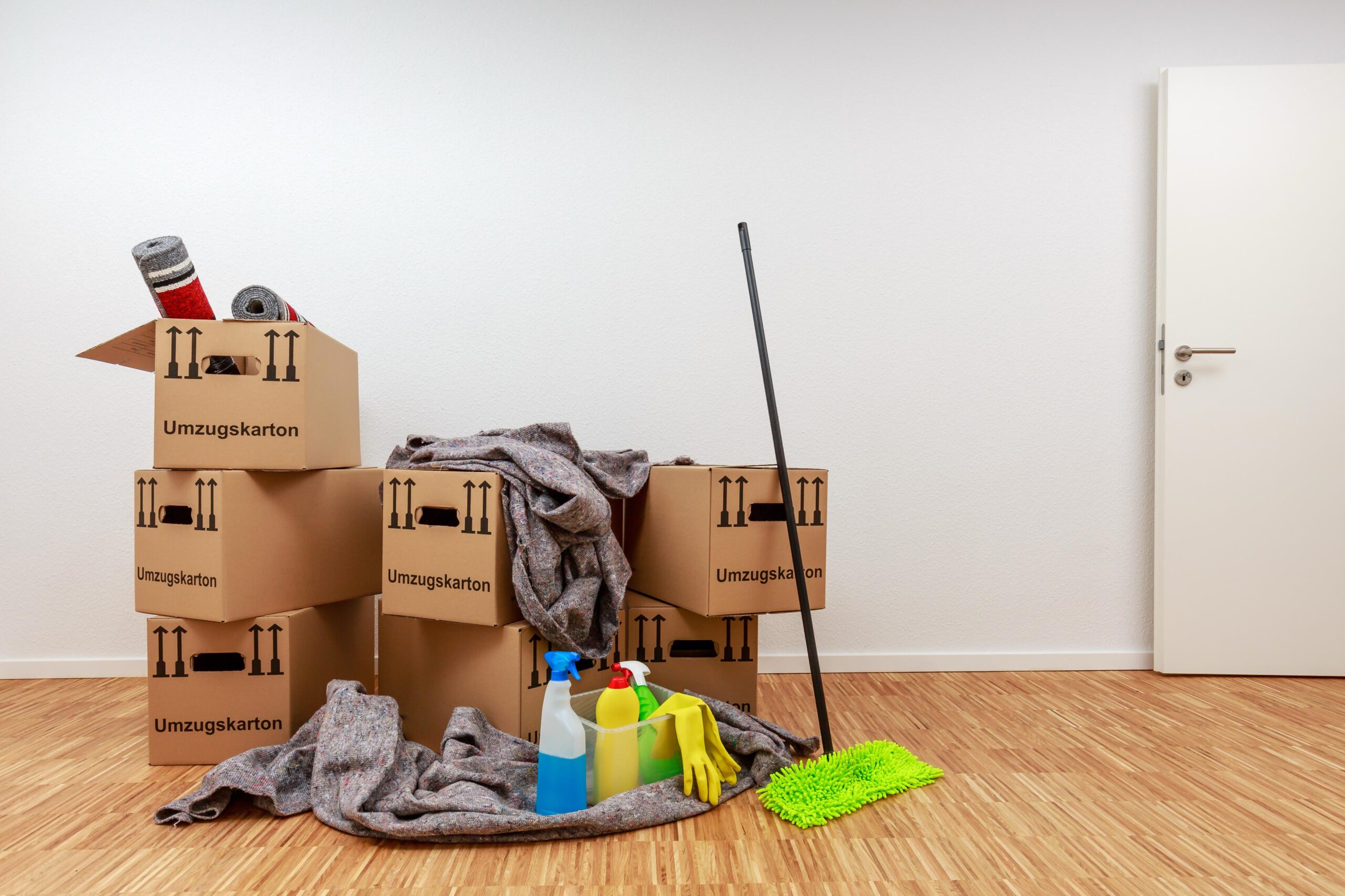 Gestapelte Umzugskartons, Reinigungsmittel und Arbeitsutensilien in einer Wohnung in Hürth vor einer professionellen Entrümpelung und Haushaltsauflösung.